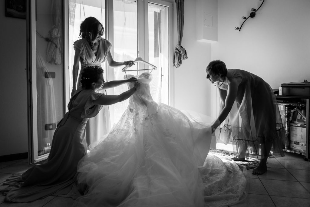Damigelle preparano il vestito della sposa